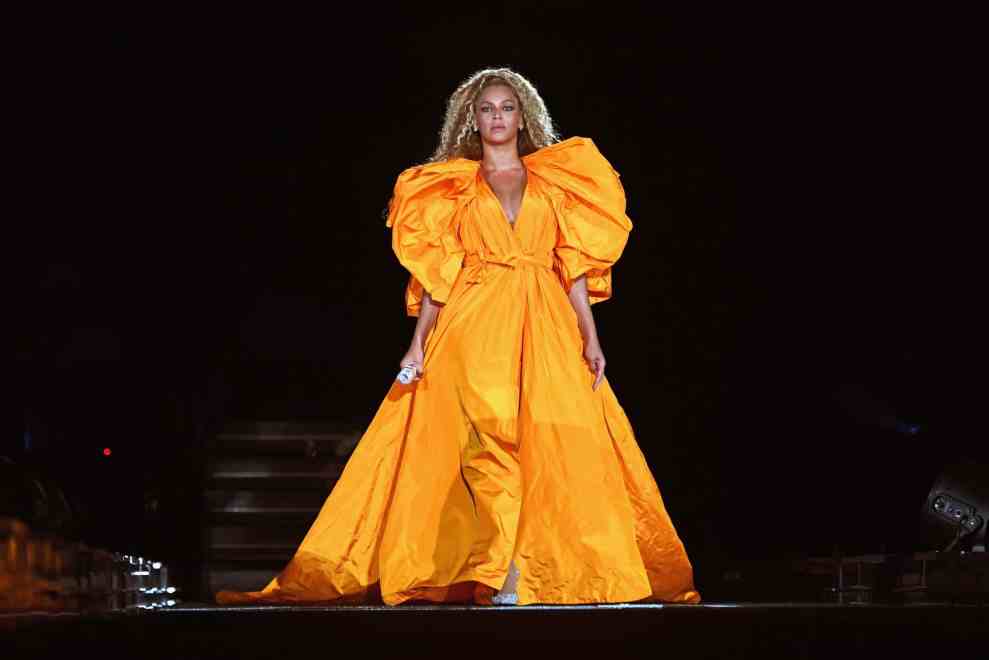 Beyoncé performing in long orange dress