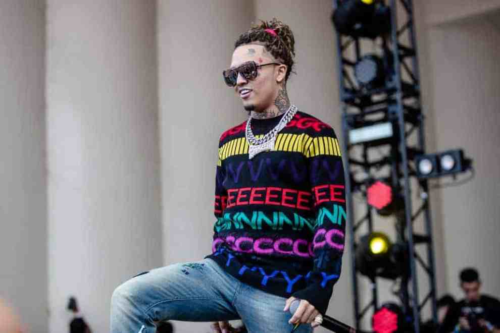 Lil Pump on stage wearing a colorful sweater and sunglasses