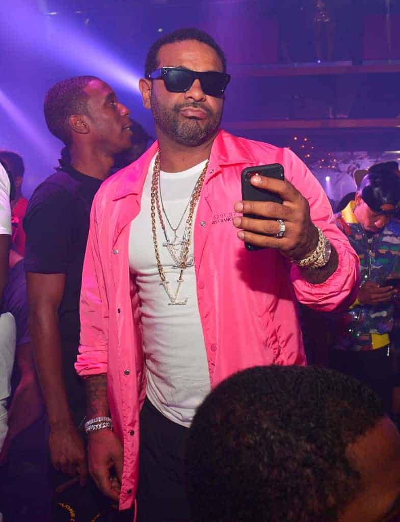jim jones with pink shirt taking picture with cell phone