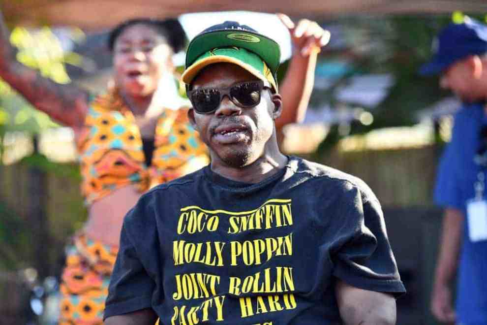 Bushwick Bill wearing black shirt and sunglasses on stage