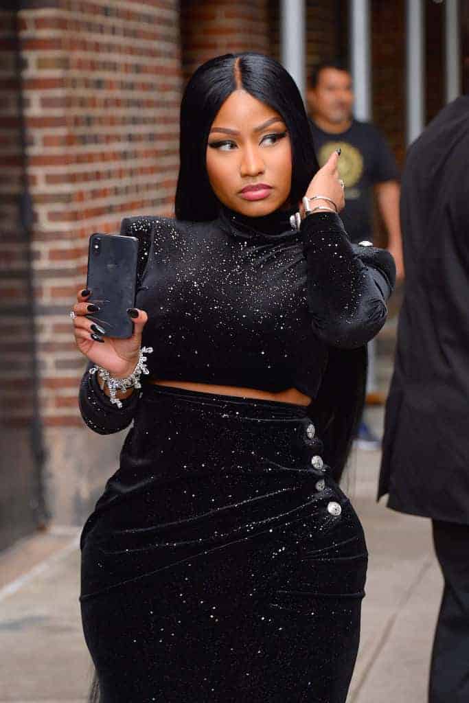 Nicki Minaj walks down street dressed in black velvet with cell phone