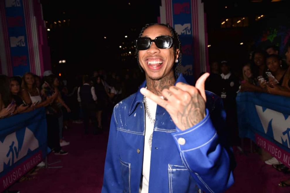 Tyga attends the MTV VIdeo Music Awards in a blue jacket and sunglasses