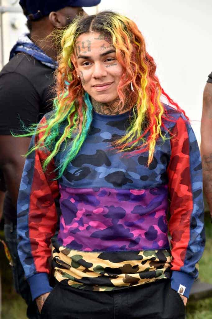 Tekashi 69 wearing a rainbow shirt to match his rainbow hair