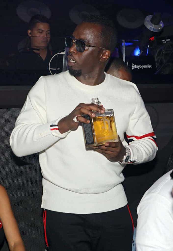 Diddy drinking from a large bottle of alcoholaq1