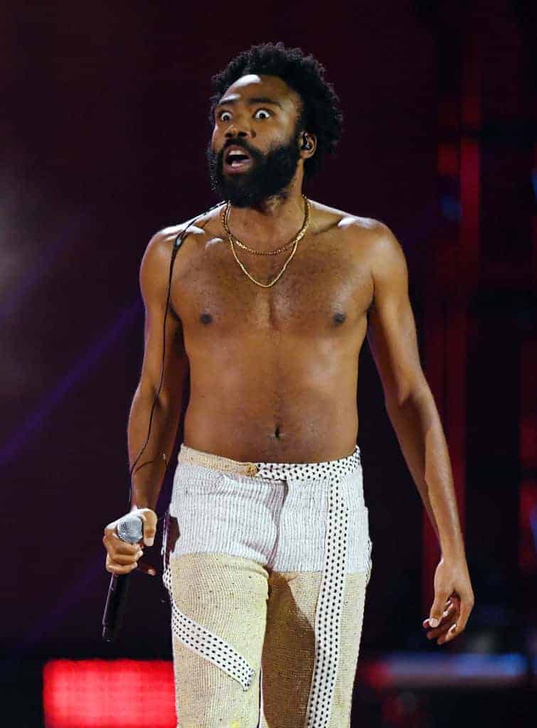 Childish Gambino wearing white pants on stage