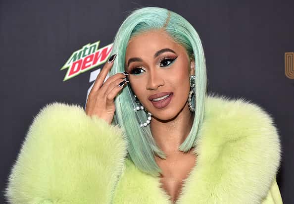 Cardi B on red carpet in yellow fur and teal hair