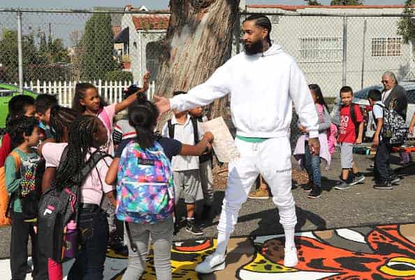 Nipsey Hussle greets kids at the Nipsey Hussle x PUMA Hoops Basketball Court Refurbishment Reveal Event on October 22
