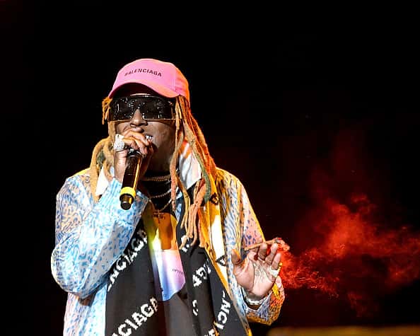 Lil Wayne performing on stage in pink hat