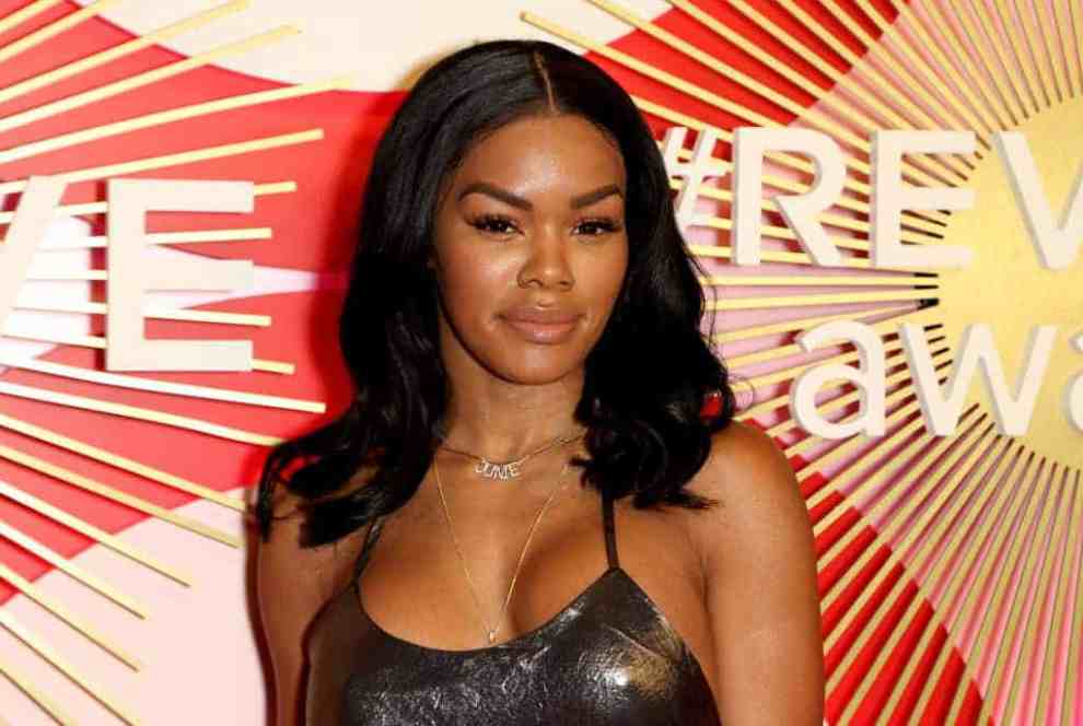 Teyana Taylor wearing a grey dress smiling at the camera