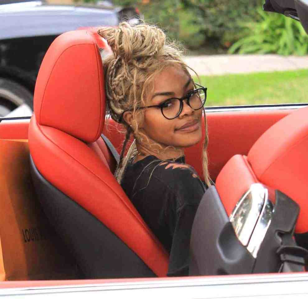 Teyana taylor sitting in the front seat of a red car in LA.