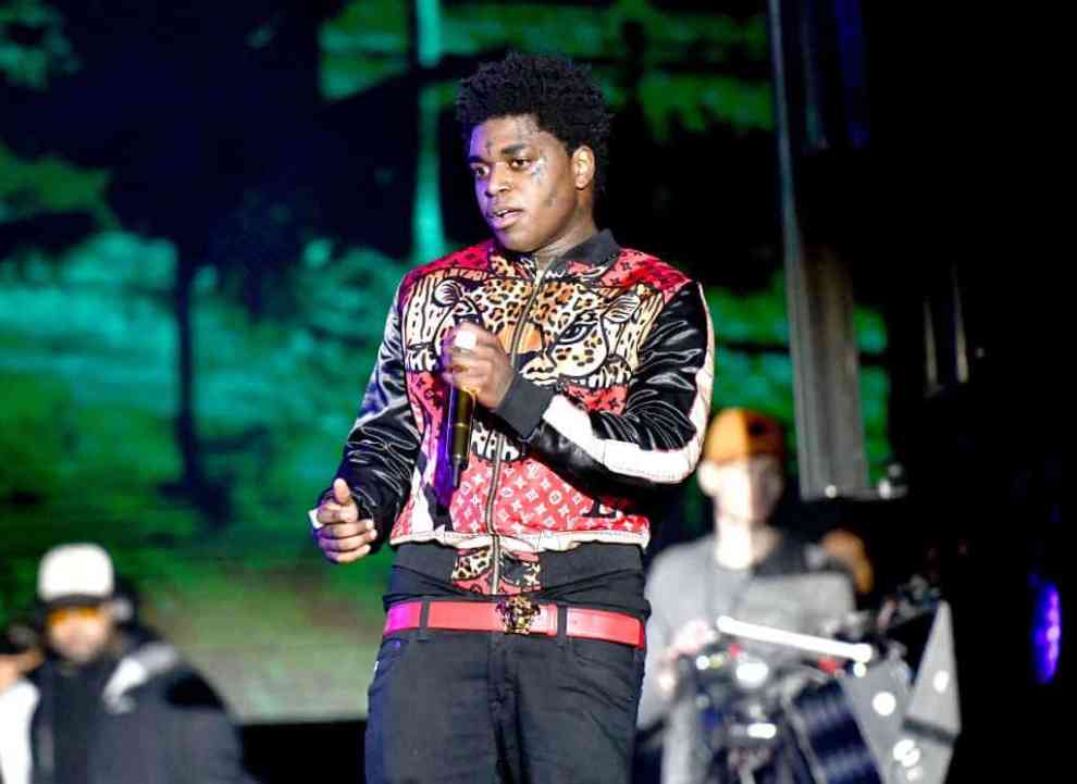 Kodak Black on stage wearing a multi-colored jacket