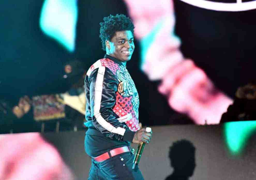 Kodak Black on stage wearing multi-colored jacket