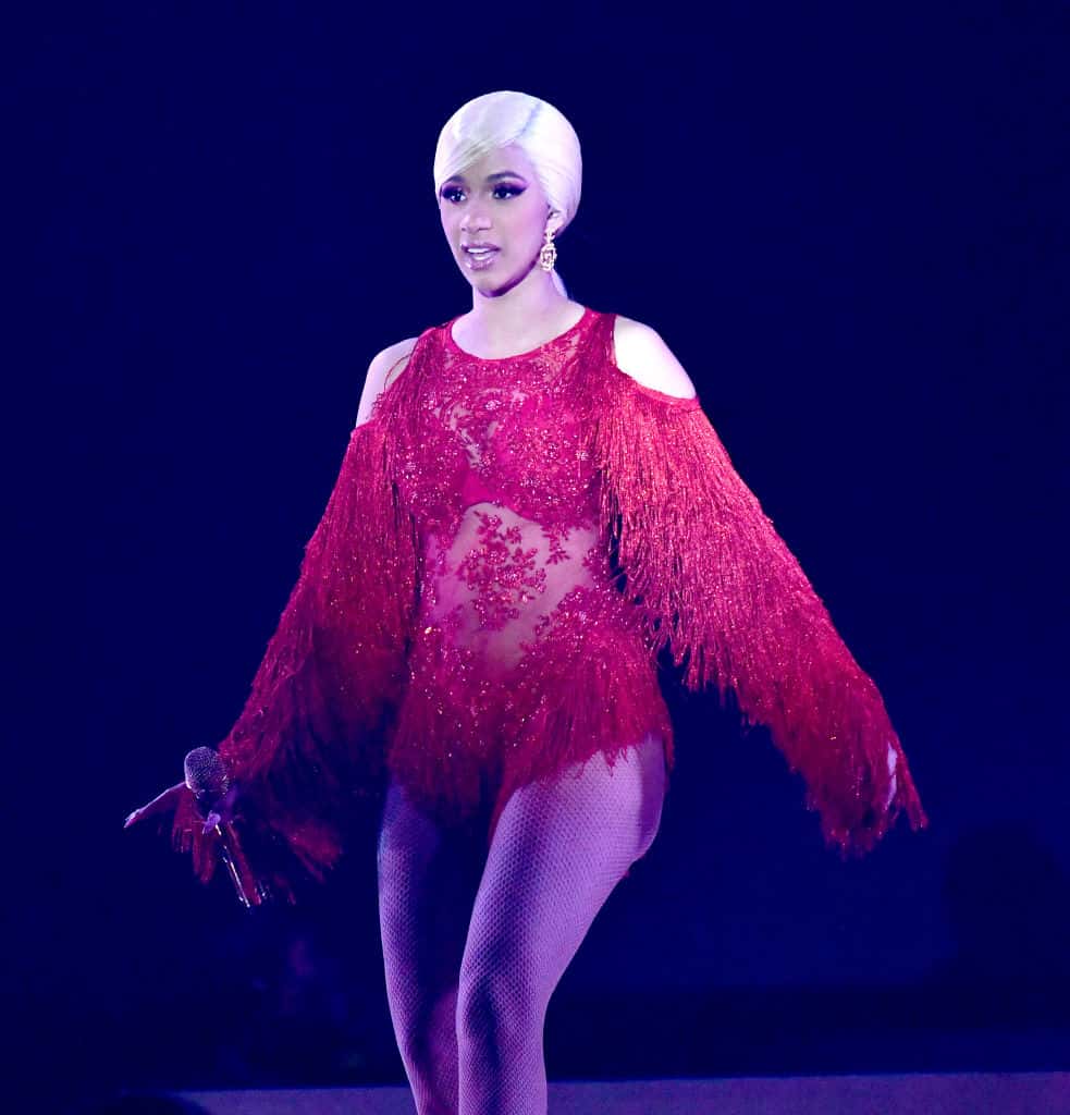 Cardi B wearing red suit performing on stage