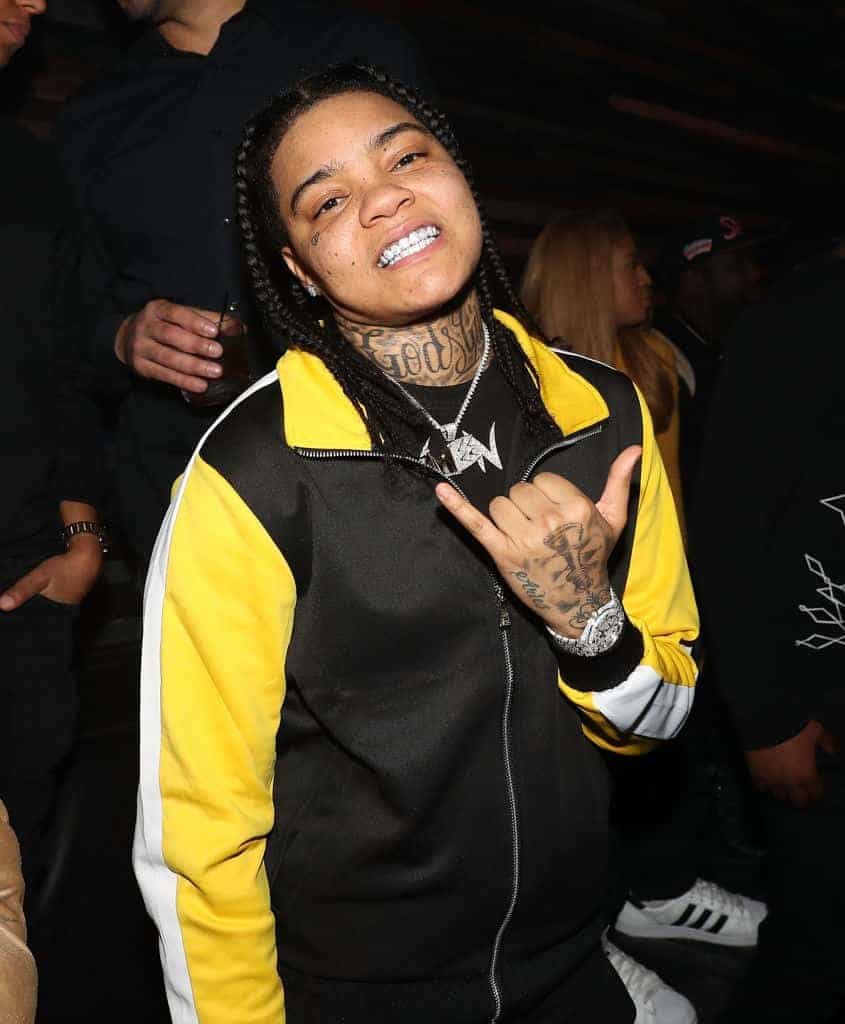 Young M.A. wearing a black and yellow shirt
