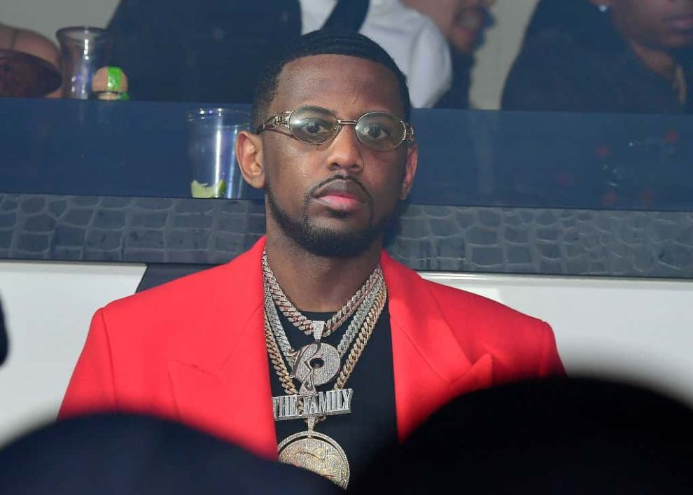 Fabolous wearing a black shirt and red jacket
