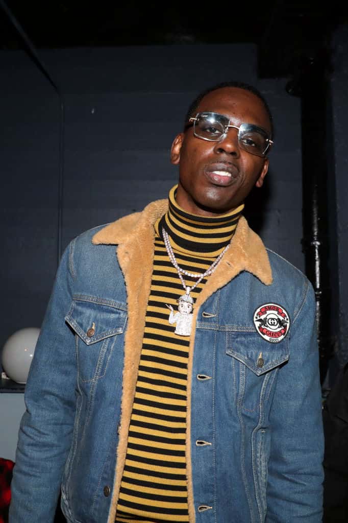 Young Dolph wearing blue jean jacket and stripe turtleneck