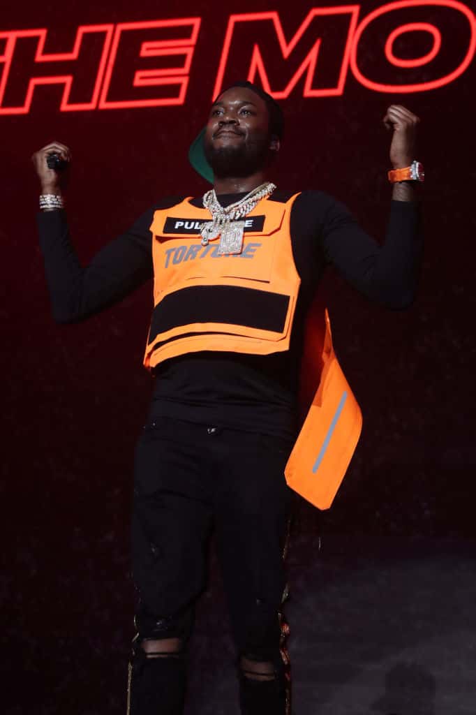 Meek Mill wearing black and orange on stage