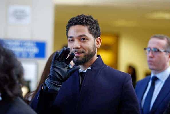 Actor Jussie Smollett waves as he follows his attorney to the microphones after his court appearance at Leighton Courthouse on M