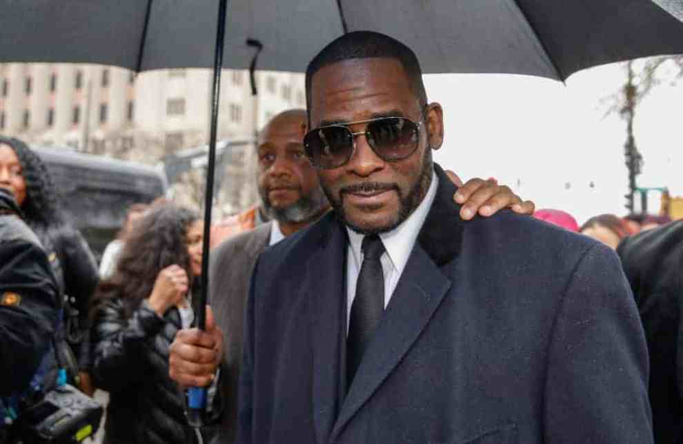 R.Kelly wearing a suit and sunglasses in court