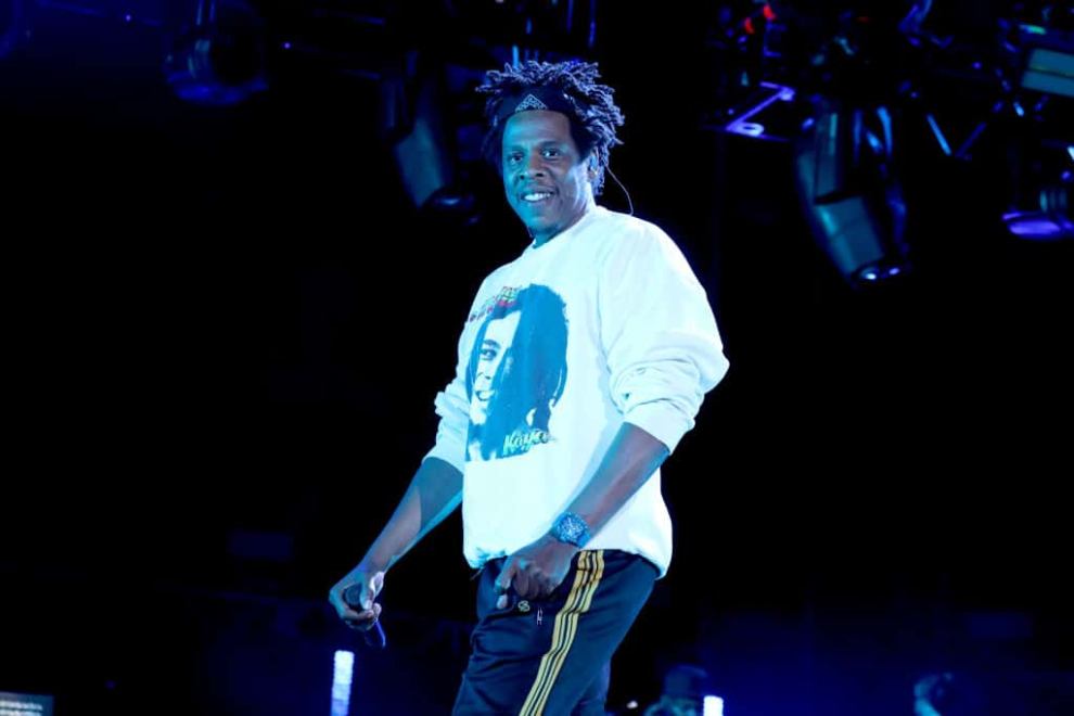 Jay-z wearing a white sweater and stage