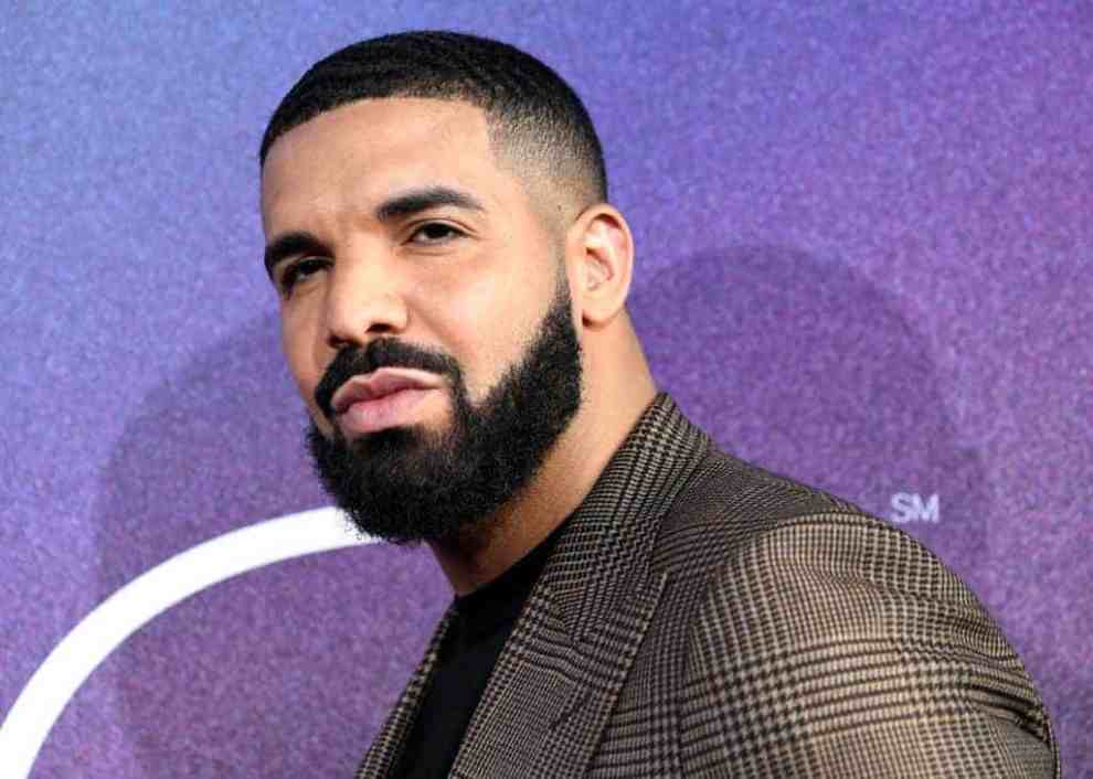 Drake wearing black turtleneck and brown blazer