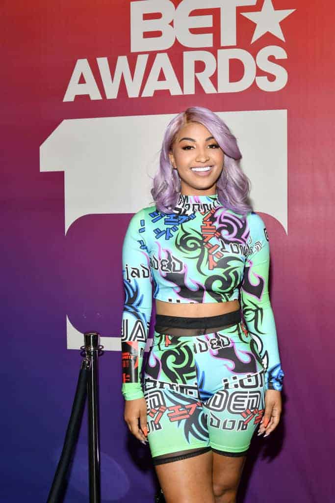 Shenseea wearing a multi-colored outfit