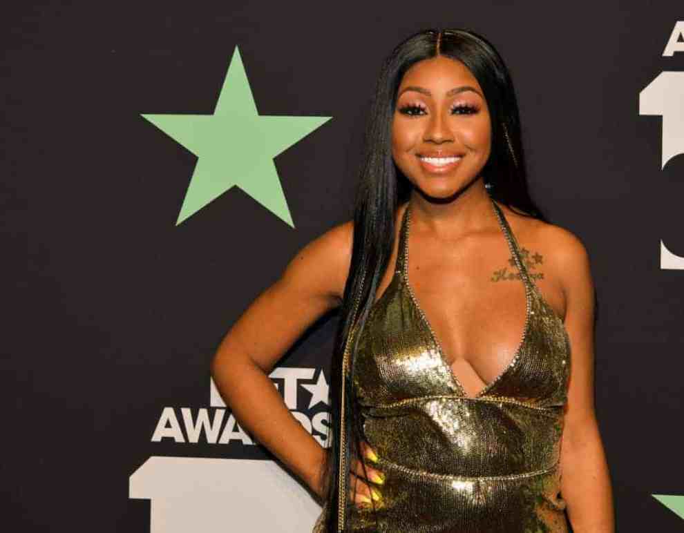 Yung Miami wearing a gold dress