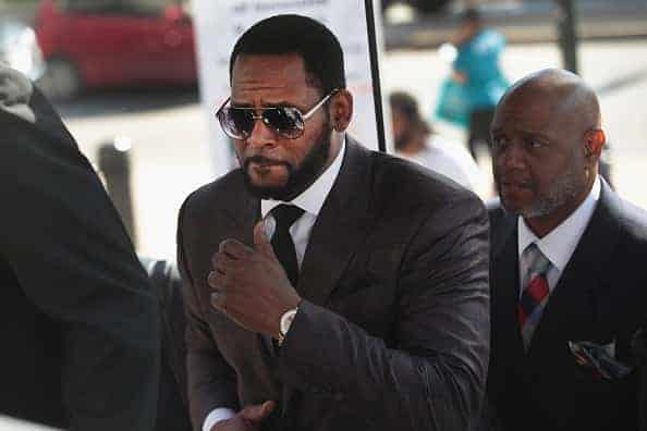 R&B singer R. Kelly (C) arrives at the Leighton Criminal Courts Building for a hearing on June 26