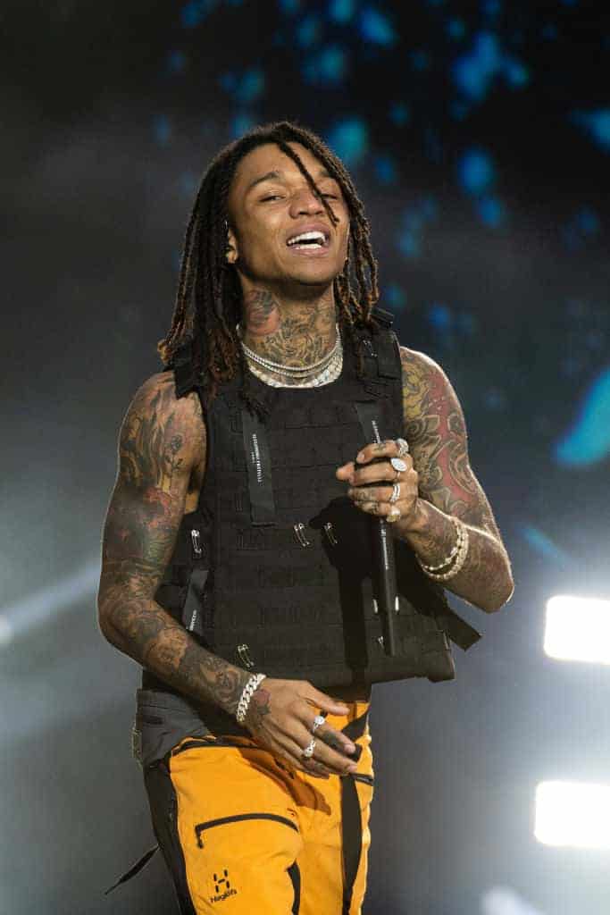 Swae Lee wearing a black vest and yellow pants