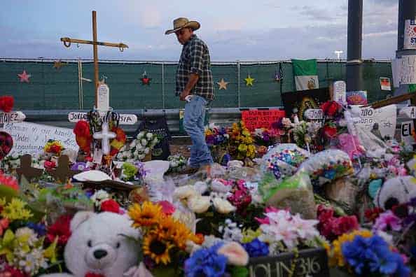 People gather at a makeshift memorial honoring victims outside Walmart August 15
