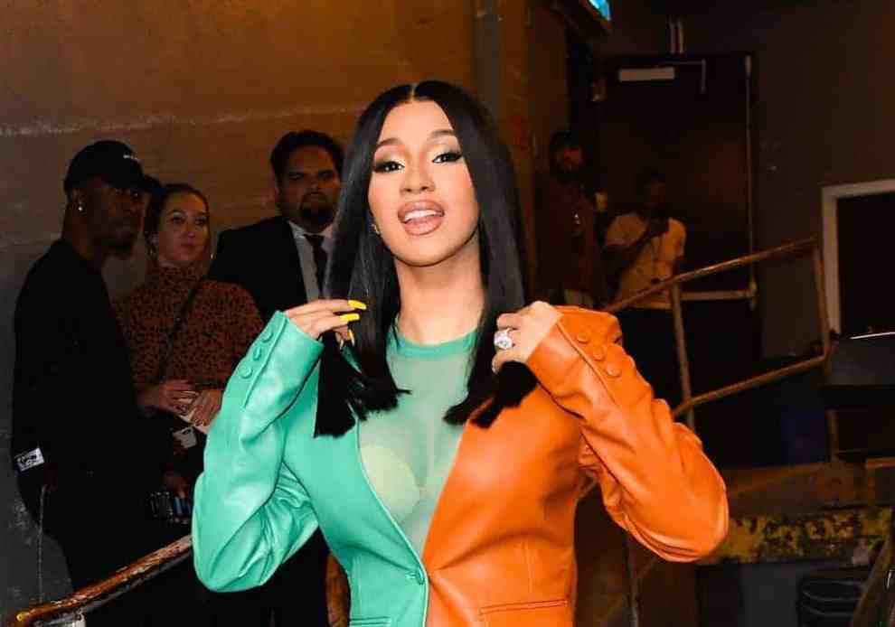 Cardi B wearing a green and orange suit