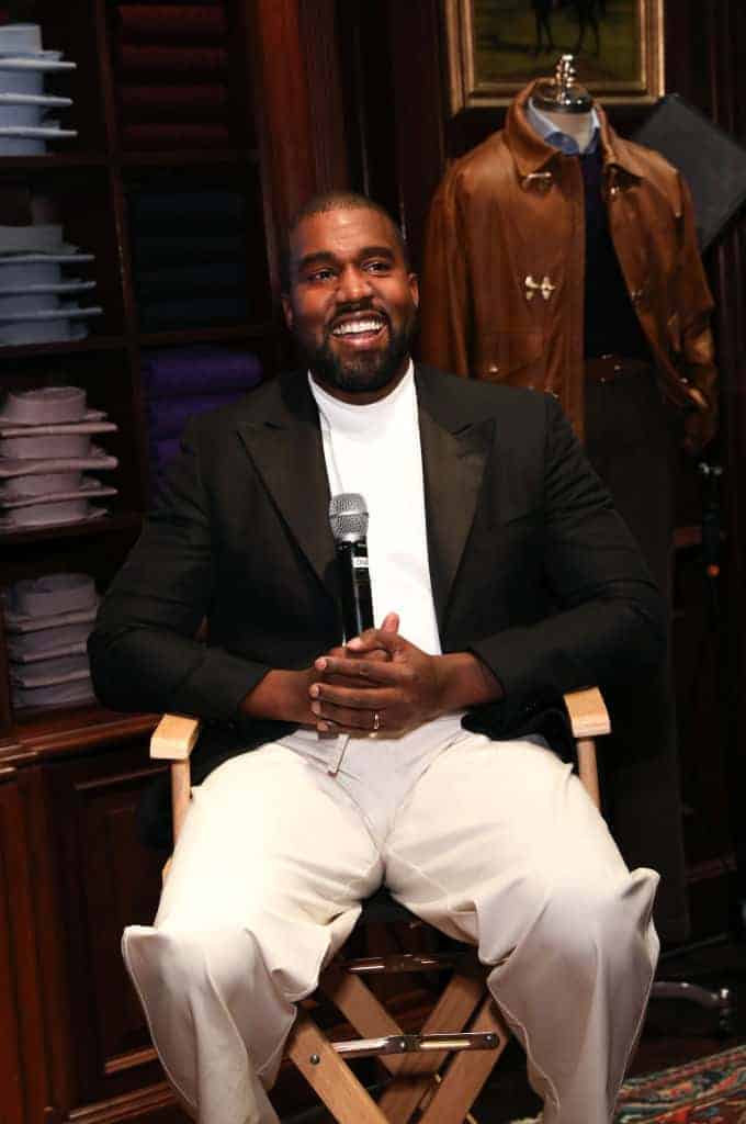 Kanye West smiling wearing a blazer