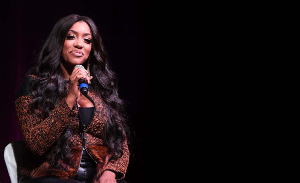 Porsha Williams on stage holding a microphone