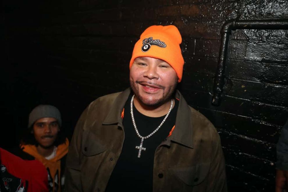 Fat Joe wearing an orange hat and black shirt