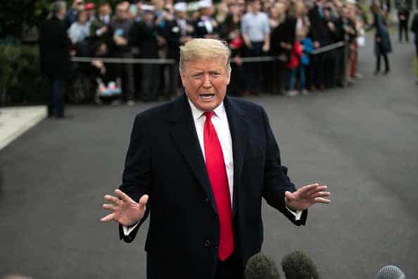 U.S. President Donald Trump speaks to the media before departing from the White House on January 13