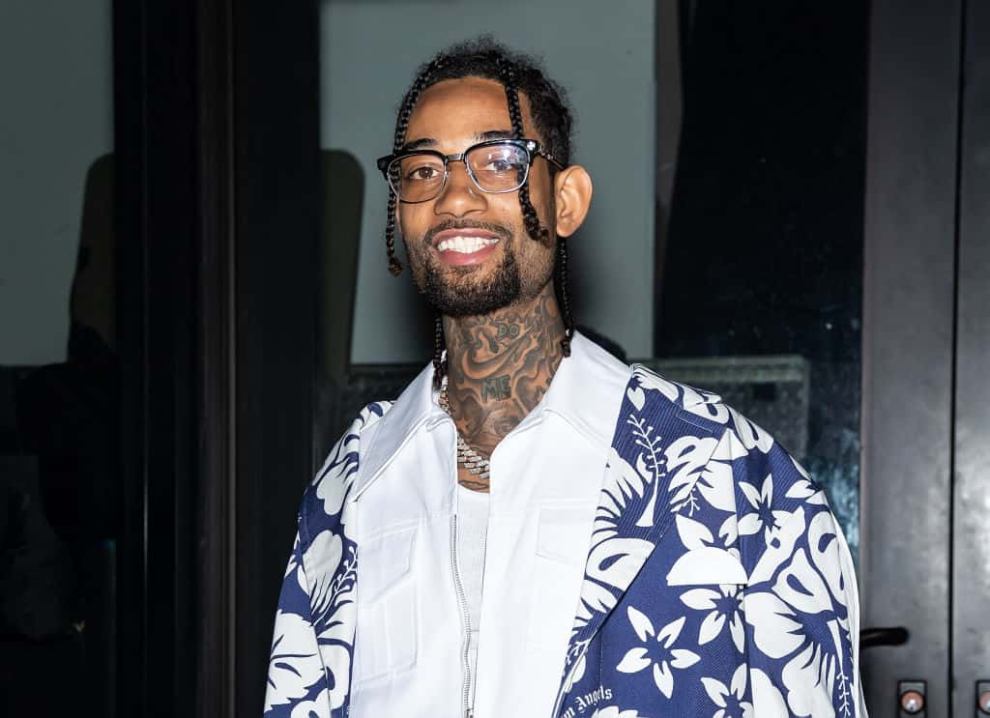 PnB Rock wearing white and blue and smiling