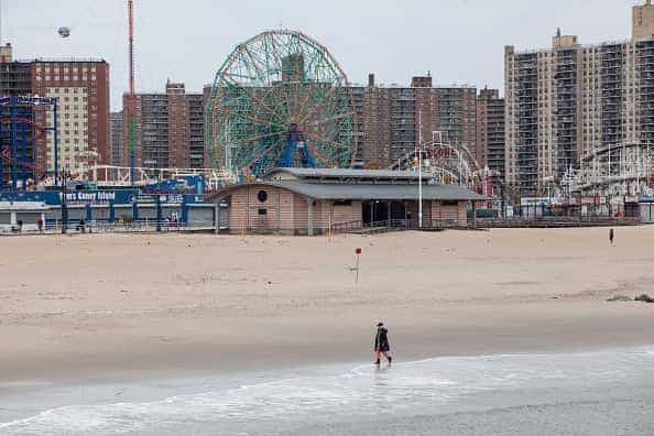 A pedestrian walks on the beach at Coney Island in the Brooklyn borough of New York