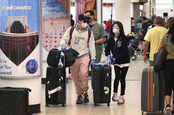 People navigate through Miami International Airport amid coronavirus fears on March 15