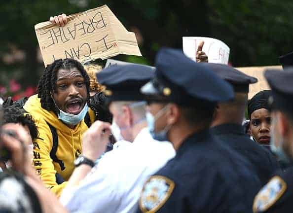 Detroit Police officers watch demonstrators in the city of Detroit