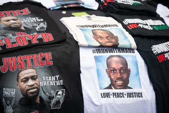 T-shirts memorializing George Floyd and Ahmaud Arbery are displayed for sale on a car hood outside the Glynn County courthouse during a court appearance by Gregory and Travis McMichael
