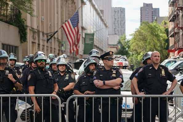 Members of the New York City Police Department look on from the Midtown North Precinct as Black Lives Matter protesters march in midtown over the death of George Floyd by a Minneapolis police officer on June 7