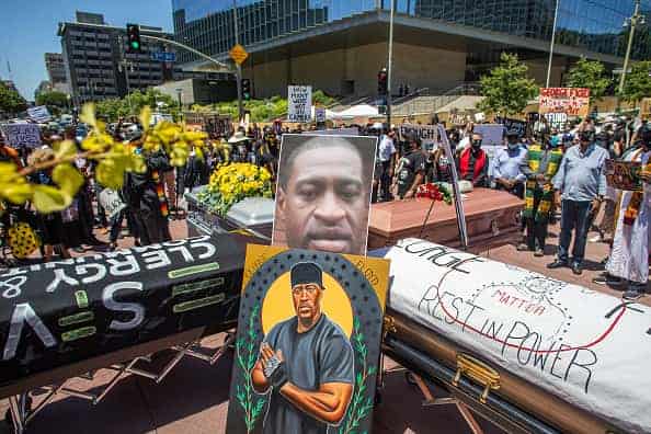 People gather in a symbolic funeral procession in Downtown at the intersection of 1st St and Broadway on June 8