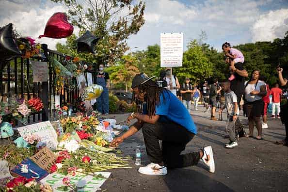 A man kneels at the memorial for Rayshard Brooks on June 14