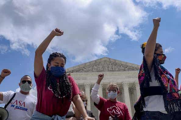 Demonstrators hold their fists in the air while kneeling outside the U.S. Supreme Court in Washington