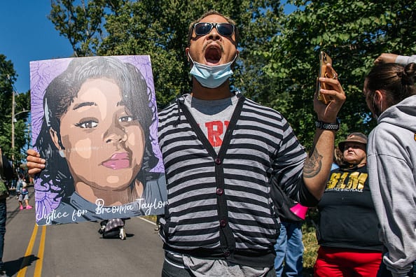 A demonstrator holds up a sign of Breonna Taylor while chanting during a protest in wake of Supreme Court Justice Ruth Bader Ginsburgs death in front of Senate Majority Leader Sen. Mitch McConnells home on September 19