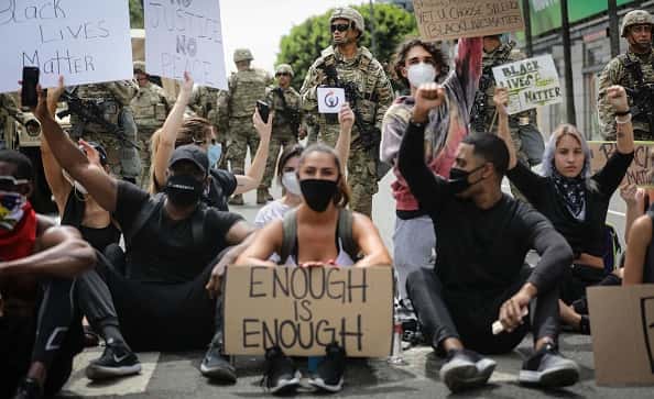 Protesters chant as National Guard troops keep watch during a peaceful demonstration over George Floyd’s death on Sunset Boulevard in Hollywood on June 2