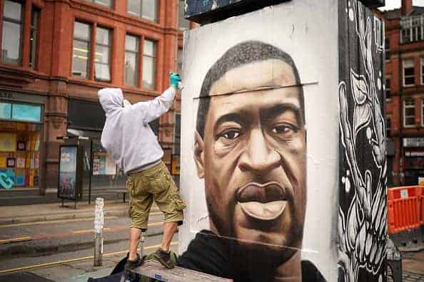 Graffiti artist Akse spray paints a mural of George Floyd in Manchester's northern quarter on June 03