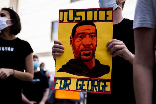 A protester holds a sign commemorating George Floyd during the Hollywood talent agencies march to support Black Lives Matter protests on June 06