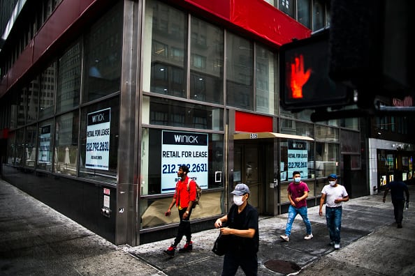 People walk by a space available to rent on August 19