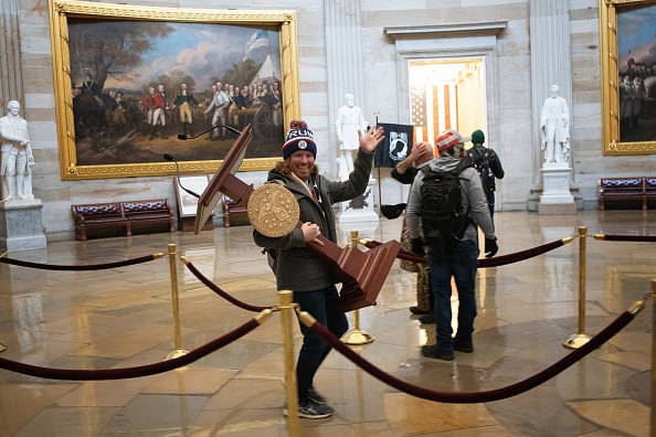 A pro-Trump protester carries the lectern of U.S. Speaker of the House Nancy Pelosi through the Roturnda of the U.S. Capitol Building after a pro-Trump mob stormed the building on January 06